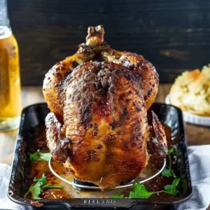 Deliciously cooked beer can chicken on a grill, showcasing crispy skin and juicy meat.