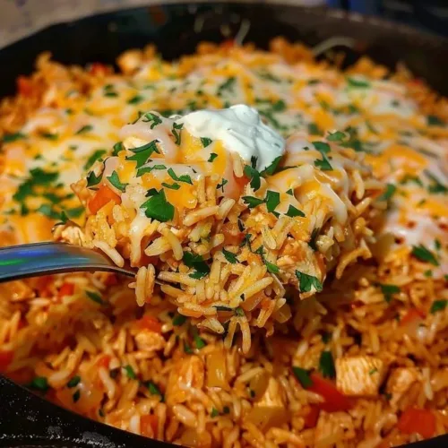 Plate of cheesy chicken taco rice with colorful toppings