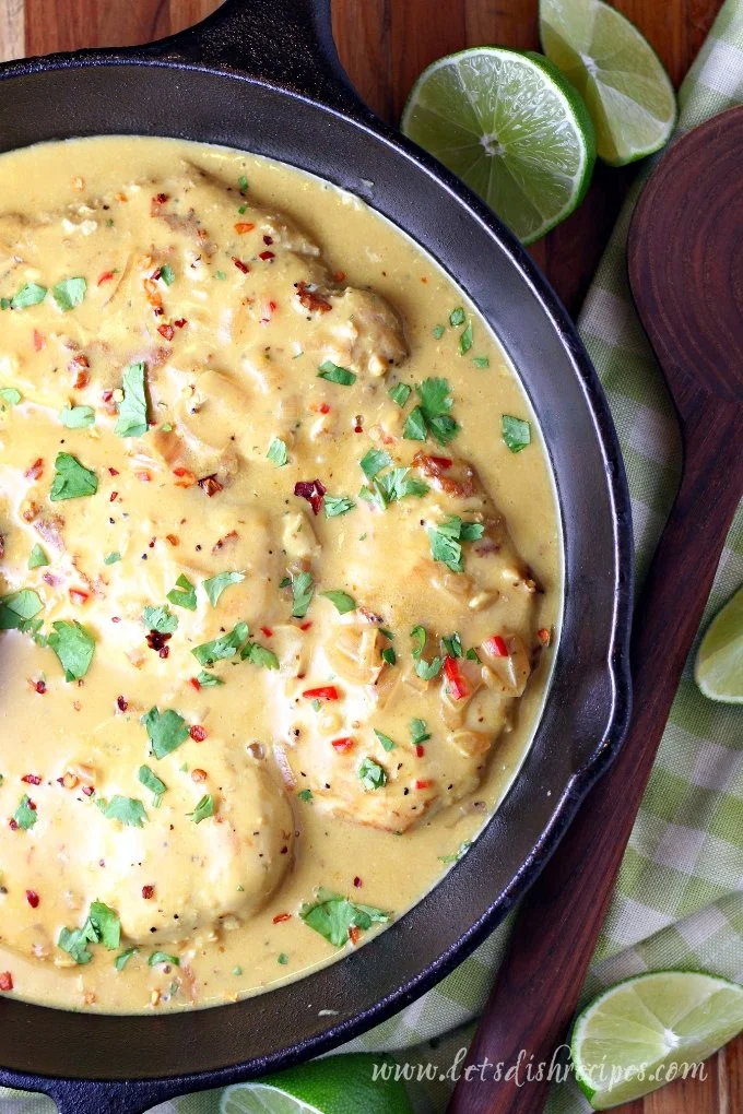 Creamy coconut lime chicken on a plate garnished with fresh herbs