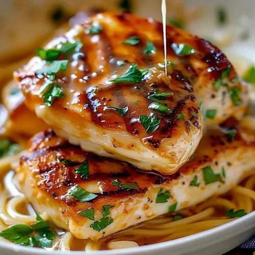 Creamy Parmesan Chicken served with a side of vegetables and herbs.
