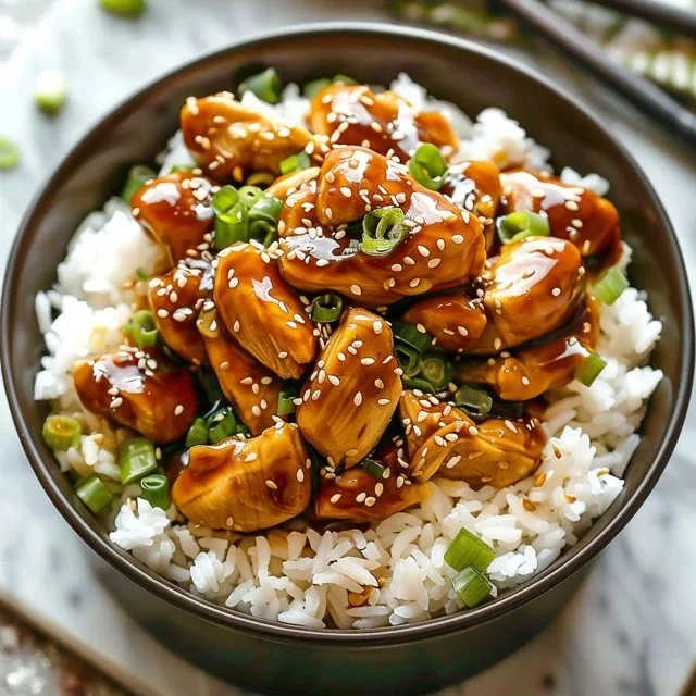 Crockpot Teriyaki Chicken in a bowl, garnished with green onions and sesame seeds