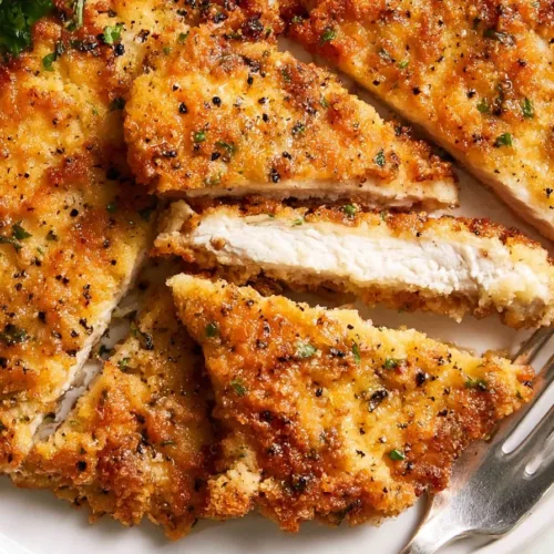Crispy Parmesan chicken cutlets served with fresh herbs and lemon